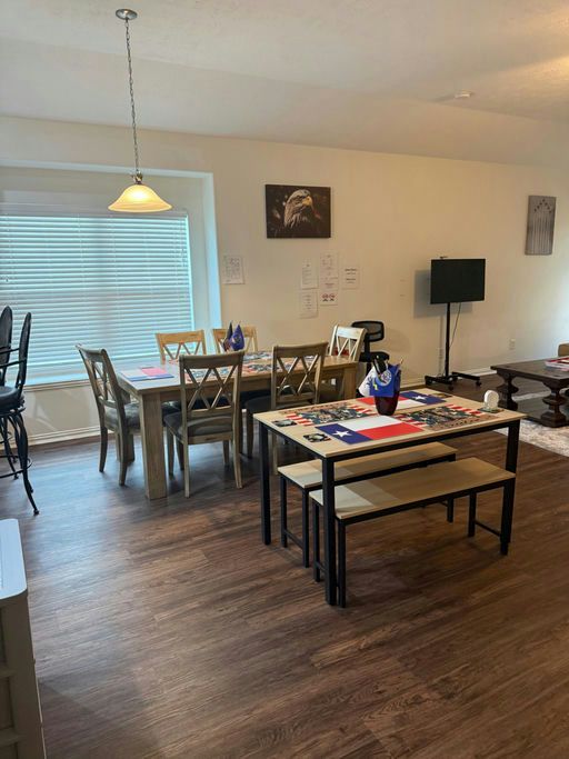 A sunny dining room with a long table, chairs and a bench