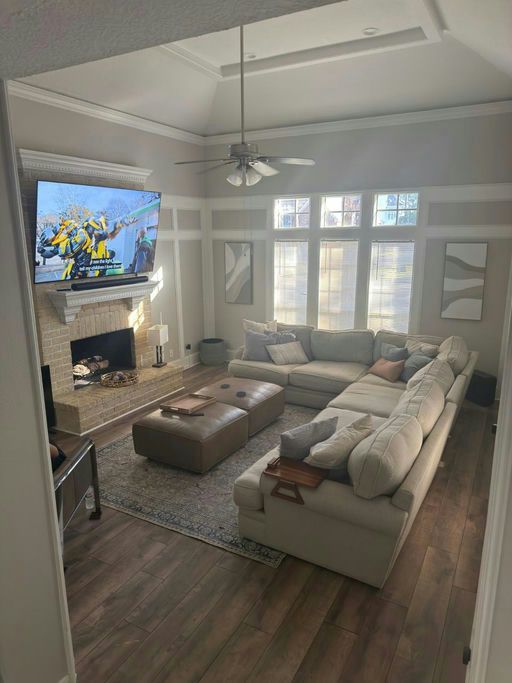 A living room with a fireplace, sofas and a vaulted ceiling with windows