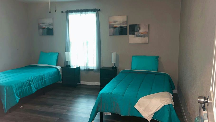 A shared bedroom with two twin beds and teal bedding